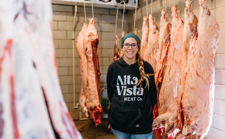 Amie Brunkow, owner of Alta Vista Meat Co., poses in her meat locker.