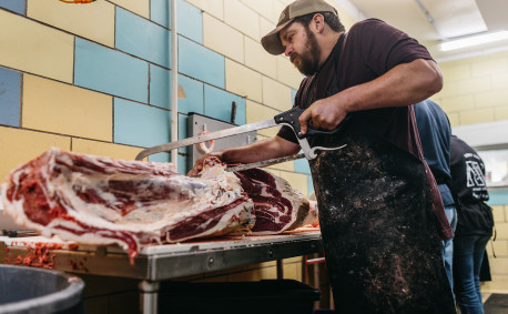 An Alta Vista Meat Co. employee saws through a particularly tough portion of a carcass.