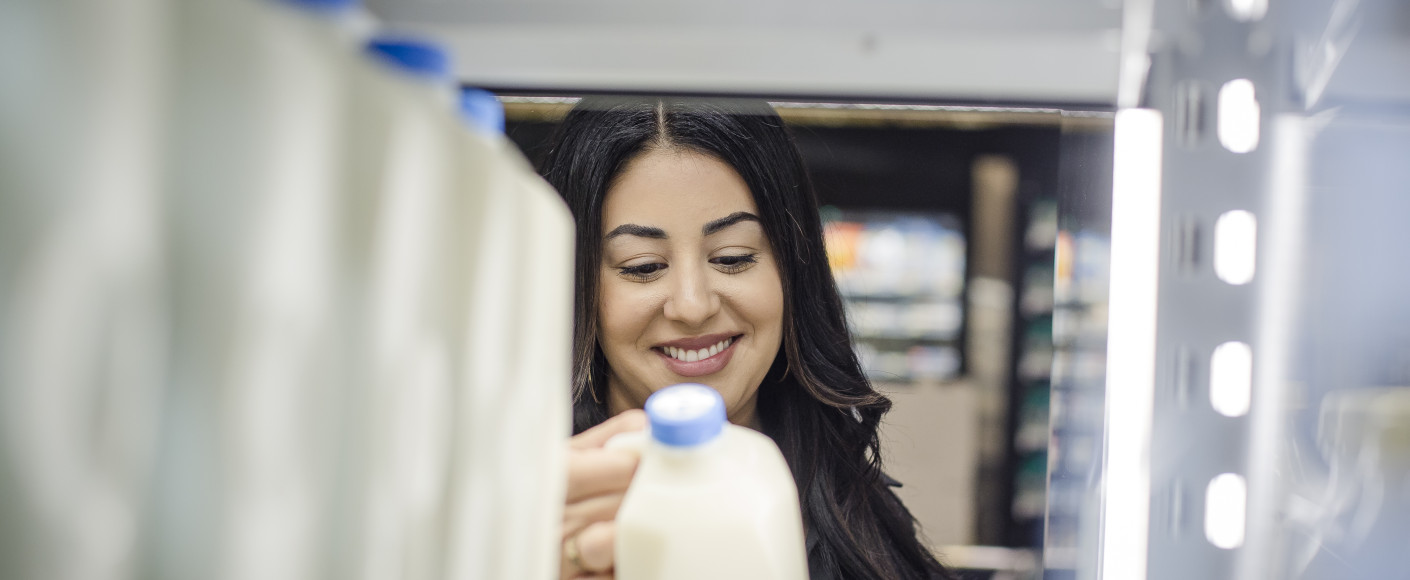 Woman buying milk at grocery