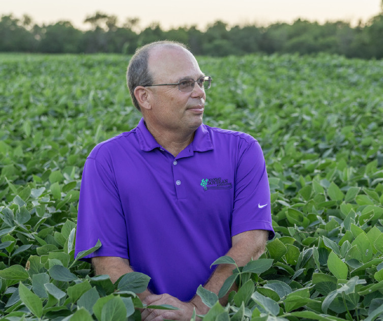 John Pracht kneeling in soybean field
